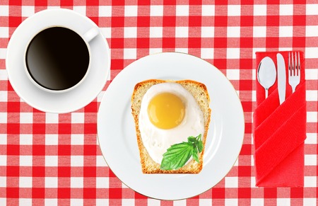 Scrambled eggs with bread on plate on color napkin and coffee cup isolated on white backgroundの写真素材