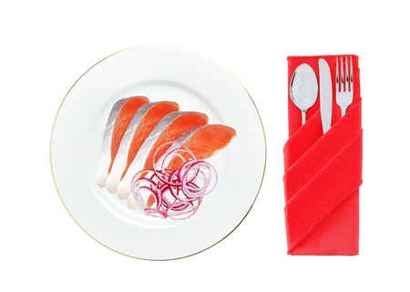 red fish with onion on the plate isolated on whiteの写真素材