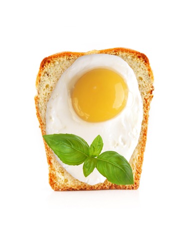 Scrambled eggs on bread with basil isolated on whiteの写真素材