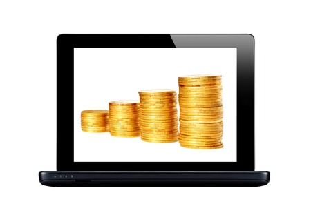 Black laptop and golden coins on screen isolated on whiteの写真素材