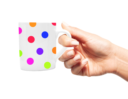 Woman hand with colorful polka dot cup of coffee isolated on whiteの写真素材