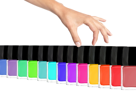Group of bright nail polishes and woman hand isolated on white backgroundの写真素材