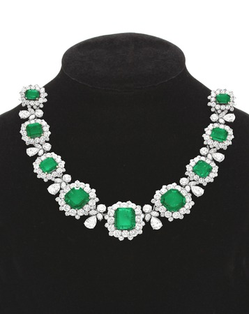 Pendant with green gem stones on black mannequin isolated on whiteの写真素材