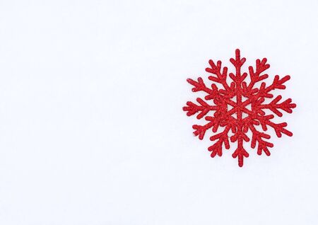 Beautiful red glitter snowflake on natural snowdrift, close upの写真素材