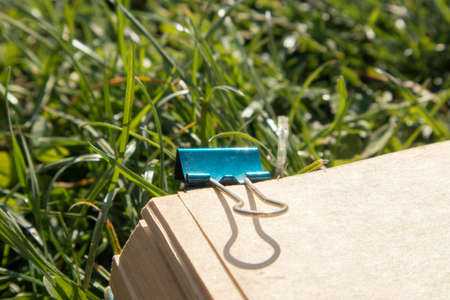 blue paper clip holding an old books pagesの写真素材
