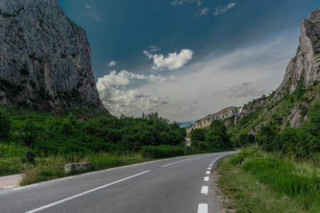 Mountain road in the mountains. Summer landscape with asphalt road and blue skyの写真素材