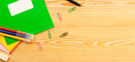 notebook, paper clips, felt-tip pens and a pen on a wooden background. view from aboveの写真素材