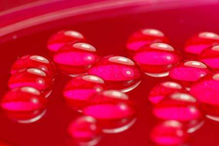 close up shoot of pink colored water dropsの写真素材