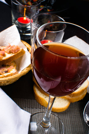 glass of red wine next to the sandwich bread and a white napkinの写真素材