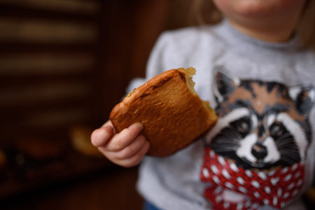 little girl in the kitchen eats sweet pastries.