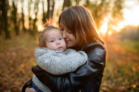 Young mother and her toddler girl in autumn fields