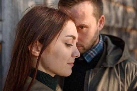 Young fashion couple posing on the street in sunny fall . Creamy autumn sunlight.