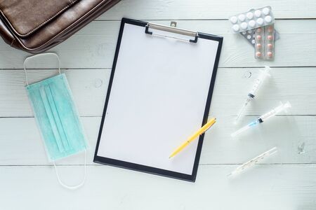 Notebook for notes, medicines, syringes. Shot on a white wooden background from above.の写真素材