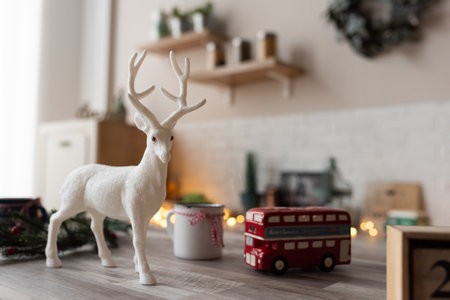 A decorative deer stands on a table in a Scandinavian kitchen. The kitchen is decorated before Christmas.の写真素材