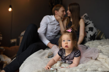 Father mom and their little one year old daughter have fun together before christmas.の写真素材