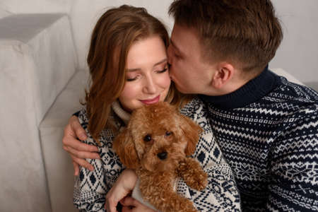 Beautiful couple relaxing at home and loving their petの写真素材