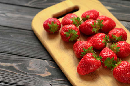 A bowl of red juicy strawberries on rustic wooden table. Healthy and diet snack food concept.の写真素材