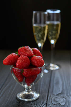 strawberries and champagne in a glass on a black backgroundの写真素材