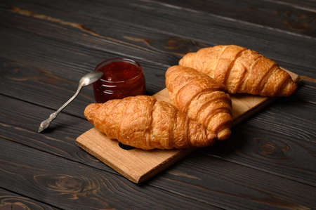 Tasty and delicious croissants with jam on a wooden tableの写真素材