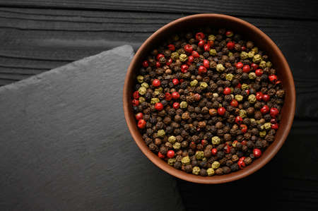 A mixture of different types of black pepper rustic backgrounds. Place for a logo.の写真素材