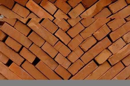 pallets and packages of freshly produced red bricks in a construction warehouse on the street....