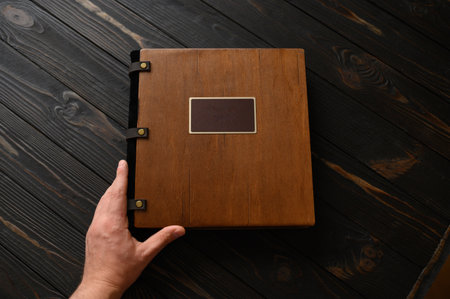 An old photo album with a wooden cover and a shield on a rustic table. free logoの写真素材