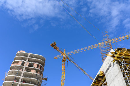 Crane and building construction site against blue sky