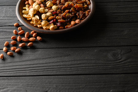 Hazelnuts, cashews, raisins, almonds, peanuts, walnuts on a wooden black background