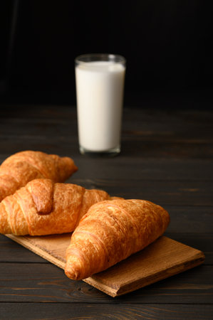 Croissants with milk on a wooden rustic background.の写真素材