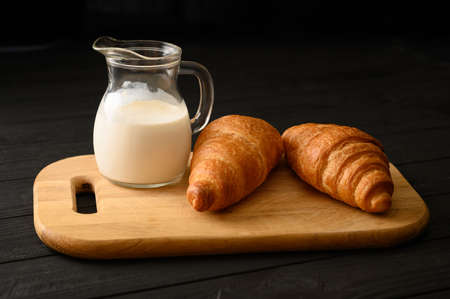 Croissants with milk on a wooden rustic background.の写真素材