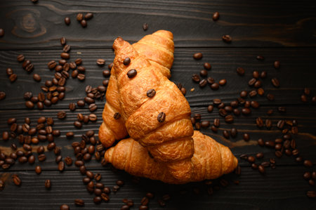 Croissants with coffee beans on a wooden background.の写真素材