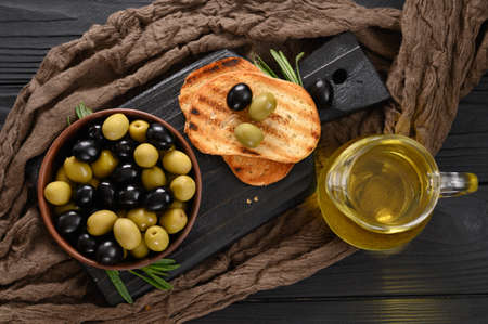 Black and green olives on a dark wooden black background.の写真素材