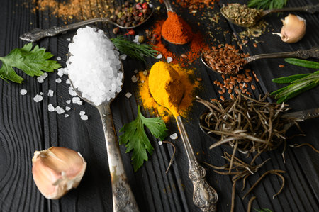 Colorful various herbs and spices for cooking on dark wooden rustic background