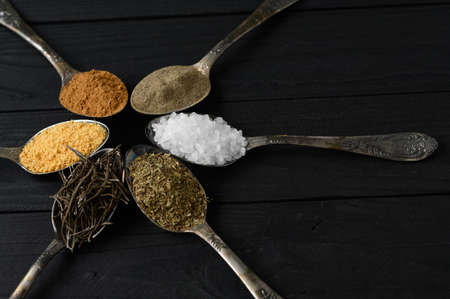 Colorful various herbs and spices for cooking on dark wooden rustic backgroundの写真素材