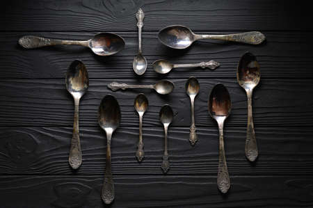 Directly above a shot of old spoons on a black tableの写真素材