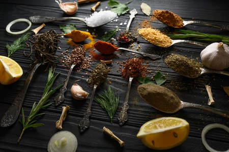 Colorful various herbs and spices for cooking on dark wooden rustic backgroundの写真素材