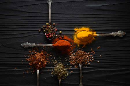 Colorful various herbs and spices for cooking on dark wooden rustic backgroundの写真素材