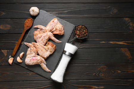 Marinated chicken wings on a rustic wooden background.の写真素材