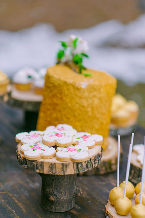cakes on a wooden table for a wedding candy bar