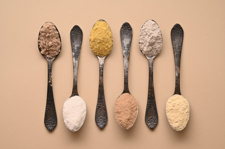Gluten free text and spoons of various gluten free flour, almond buckwheat, rice, corn, oat, chickpea. Flat lay, top.の写真素材