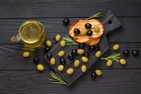Black and green olives on a dark wooden black background.の写真素材