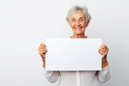 Happy old woman holding blank white banner sign, isolated studio portraitの素材