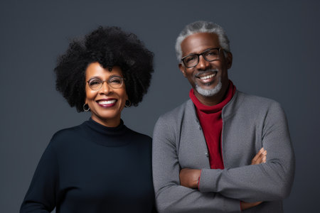 attractive mature black woman and black man with phone on studio color backgroundの素材