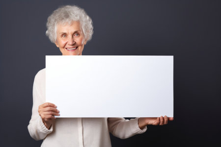 Happy old woman holding blank white banner sign, isolated studio portraitの素材
