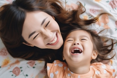Top view of a mother and her daughter laughing cheerfullyの素材