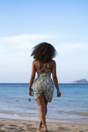 African American Woman in bikini walking towards the seaの素材