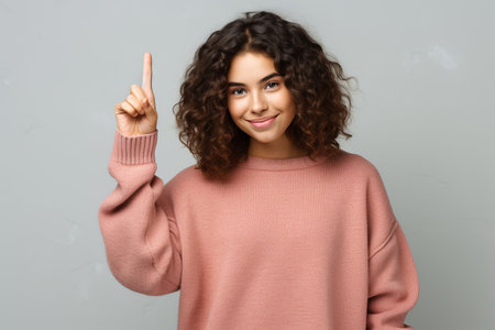 17 years old girl on a white background gesticulates with her index finger, copy spaceの素材