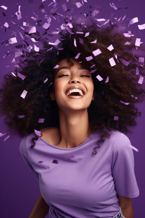Energetic active African American lady dancing moving on holiday with flying confetti isolated on violet color backgroundの素材