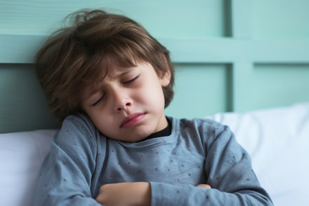 Sick child looking upset suffering from a stomach acheの素材