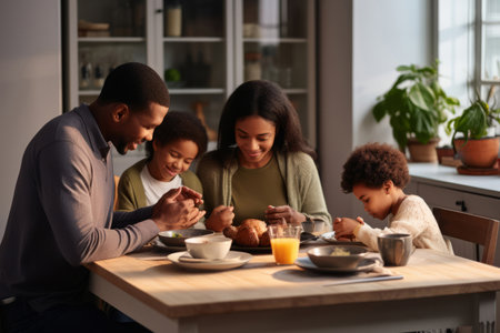 Happy multiracial family couple with children pray together before having morning breakfast at home together. Multiethnic parents with mixed race kids hold hands say prayer sit at kitchen tableの素材
